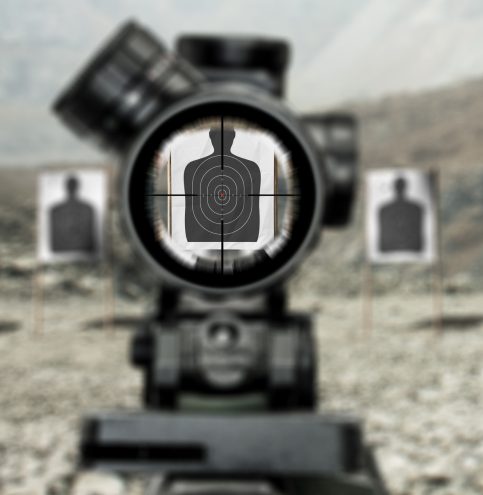 Assault rifle red dot target view, image of a rifle scope sight used for aiming with a assault weapon rifle at shooting range